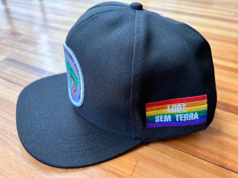 BONÉ PRETO LGBT - Aba interna com arco-íris, escrita “LGBT” branco e bandeira LGBT SEM TERRA na lateral